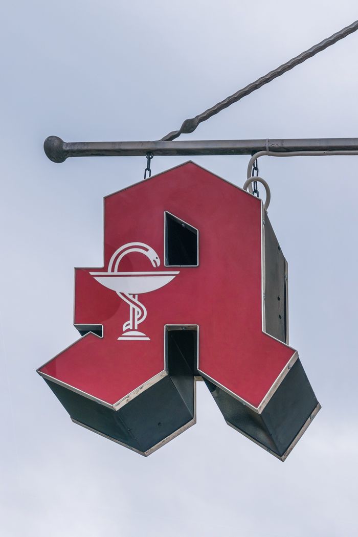 services-02 Outdoor pharmacy sign featuring a red symbol with a snake icon, ideal for healthcare themes.