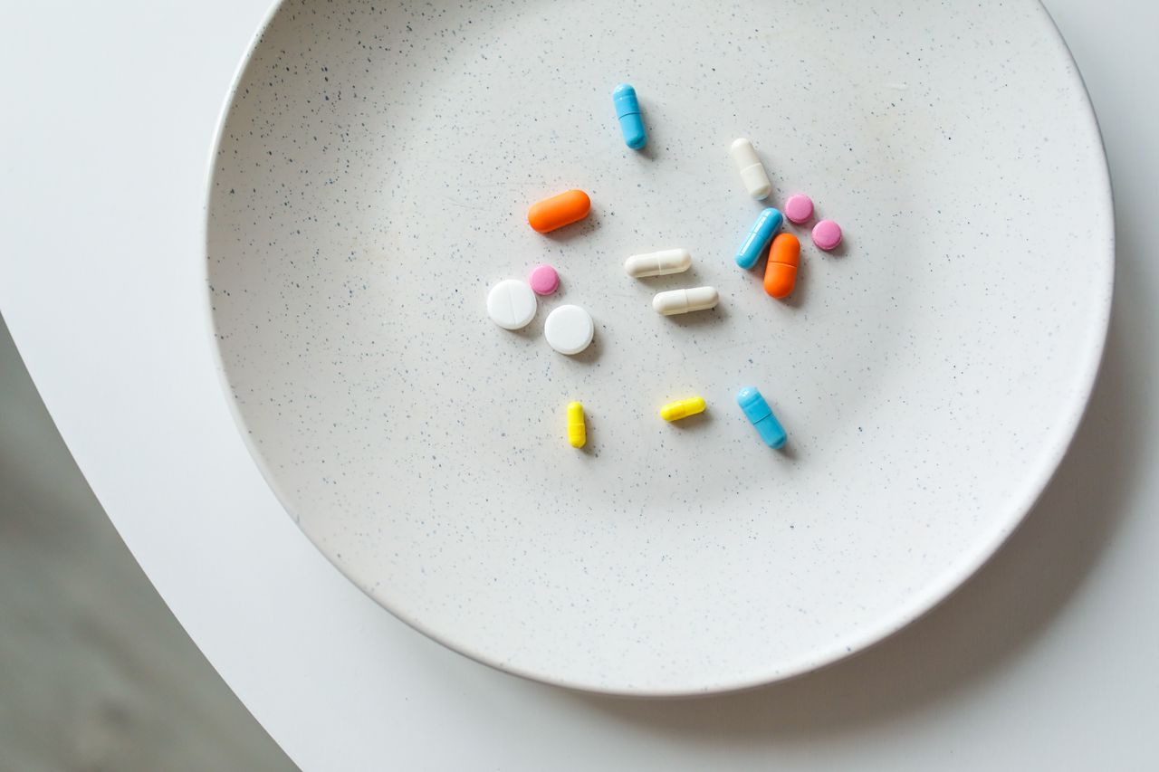 services-03 A variety of colorful medicine pills arranged on a white plate, symbolizing healthcare.