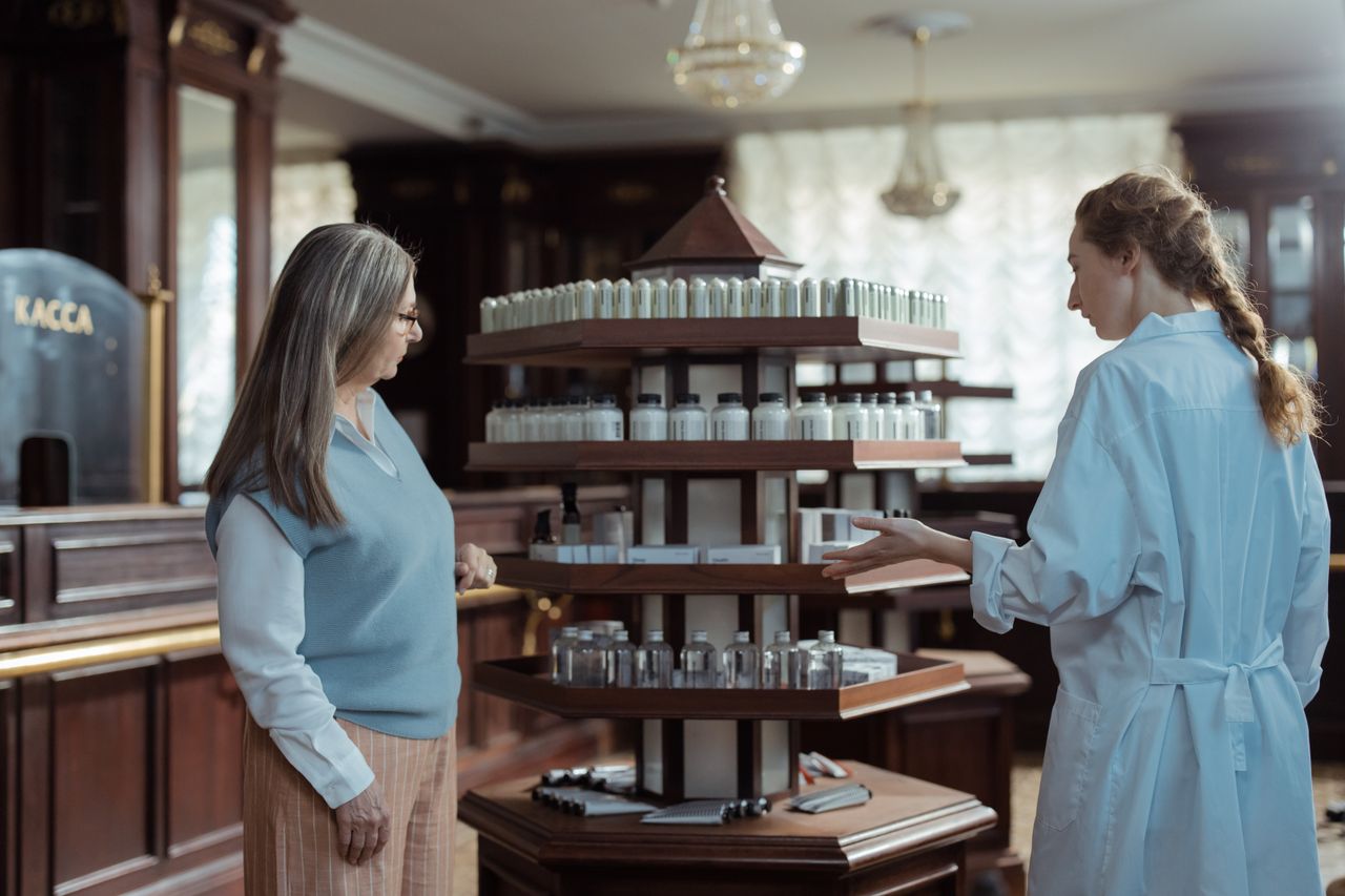 services-04 Pharmacist helps customer in elegant pharmacy with rotating product display.